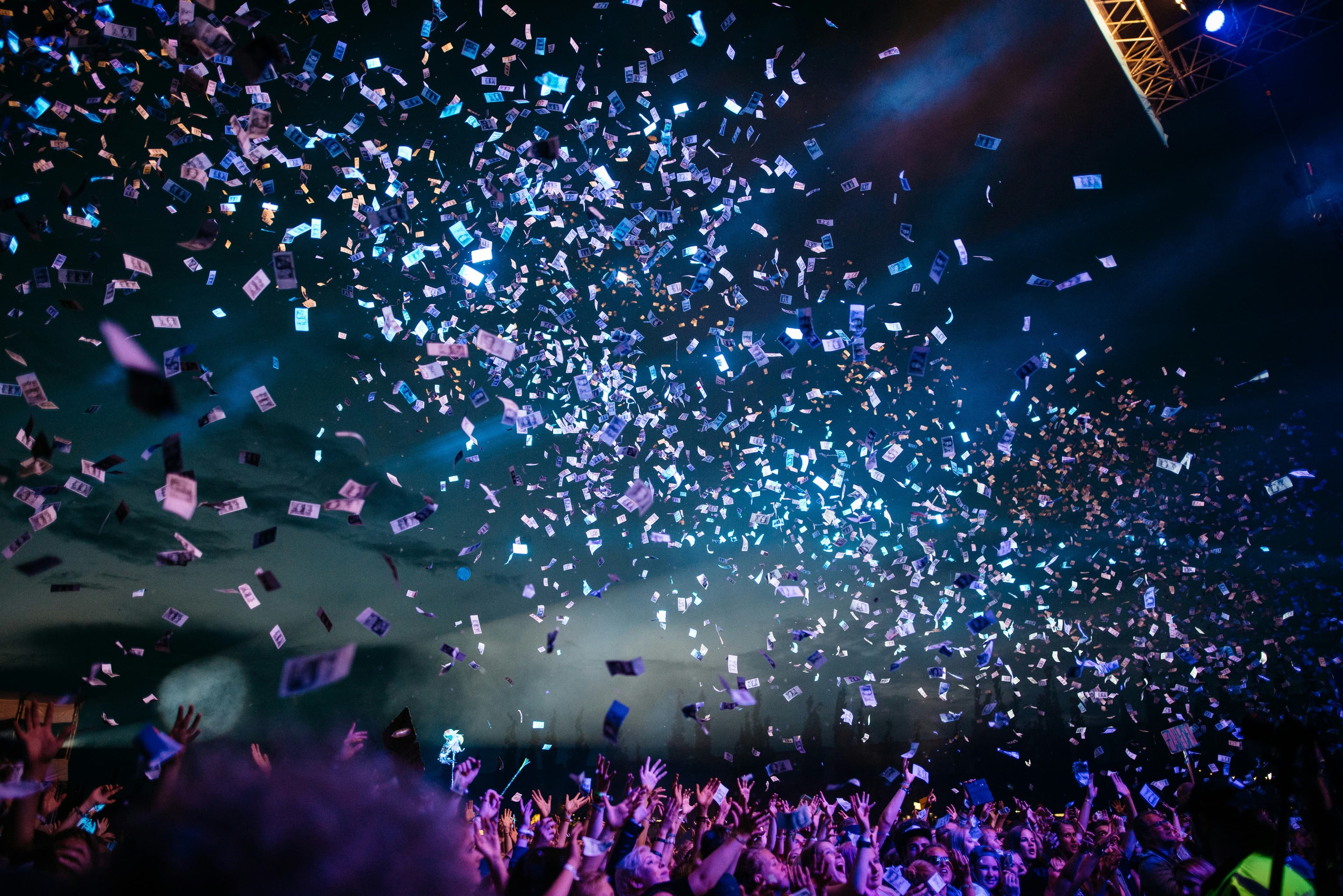 Confetti falling over a cheering crowd at an event